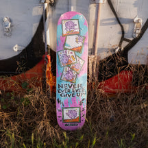 Colorful skateboard deck with motivational text on a grassy background