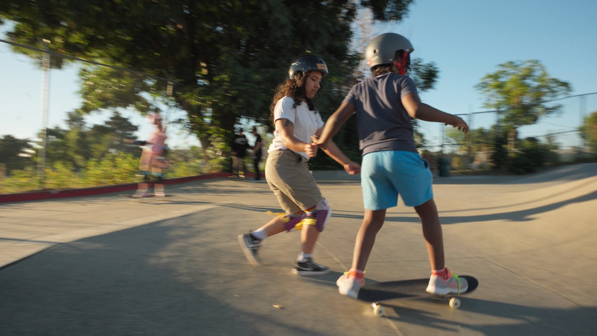 Yvette coaching a young skater at a skatepark